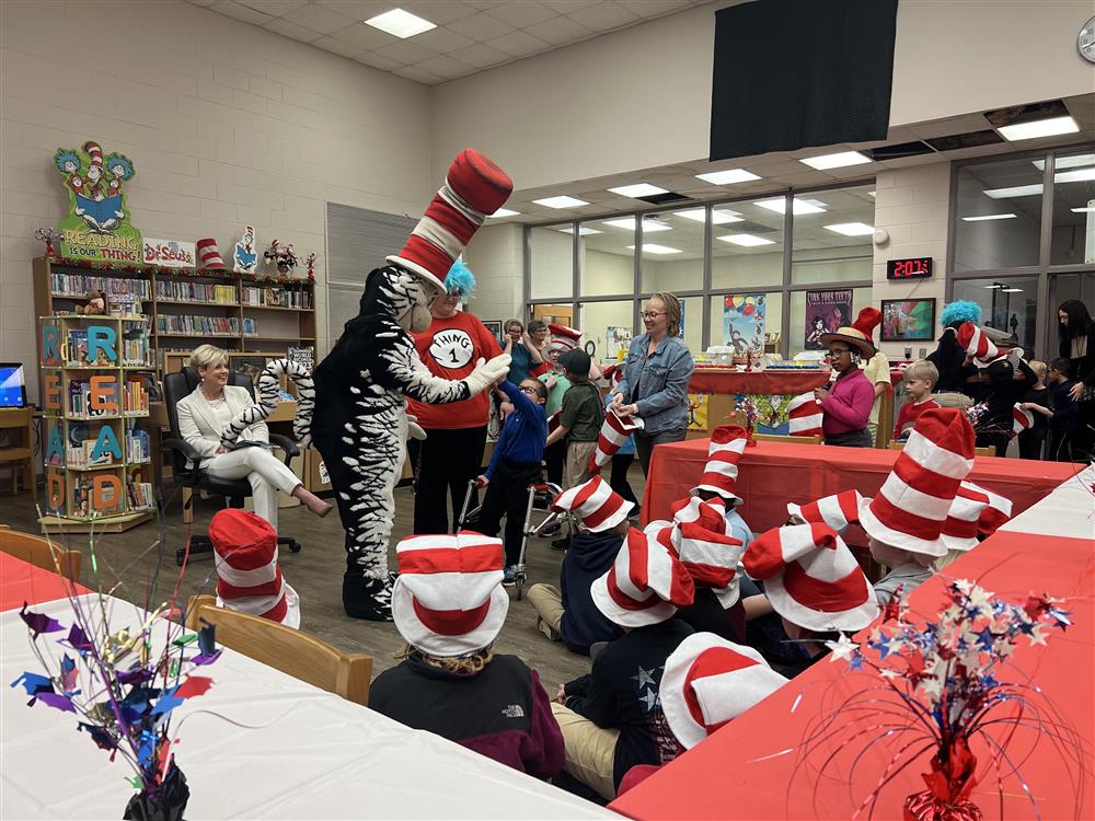 Asher Cobb welcomed with a high five by the Cat in the Hat to his first Read Across America event.